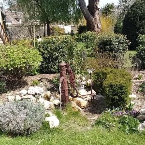 Composition paysagère autour d'une pompe en fonte